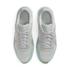 Overhead view looking down at the laced white running shoes, displaying the flat white laces, mint branding on the tongue labels, and the comfortable printed insoles.