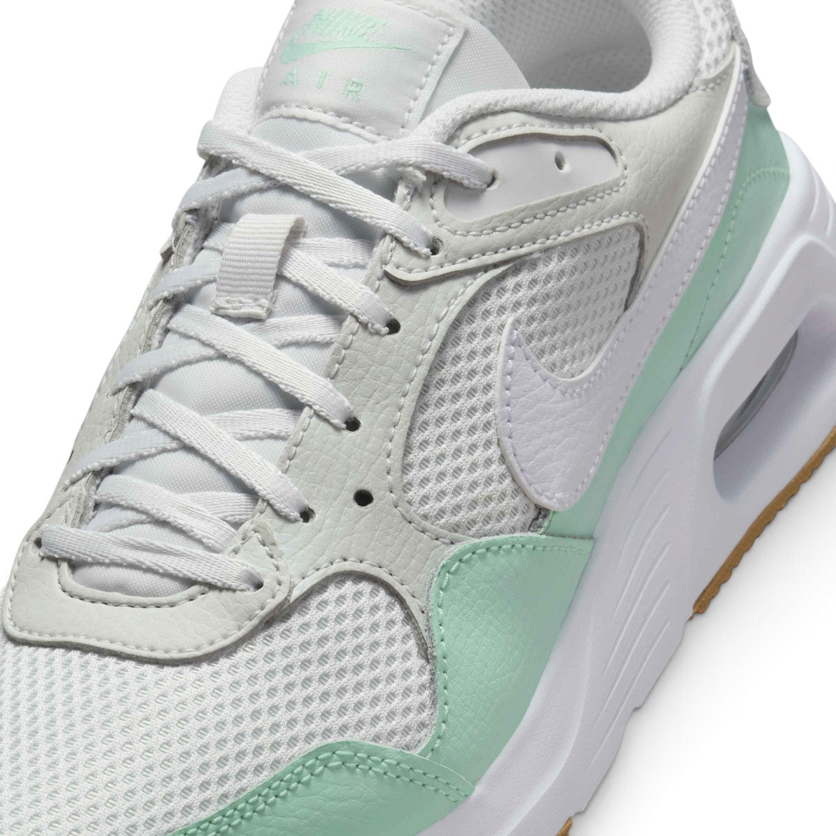 Macro focus on the breathable mesh texture, synthetic eyestays, and matching white flat athletic laces.