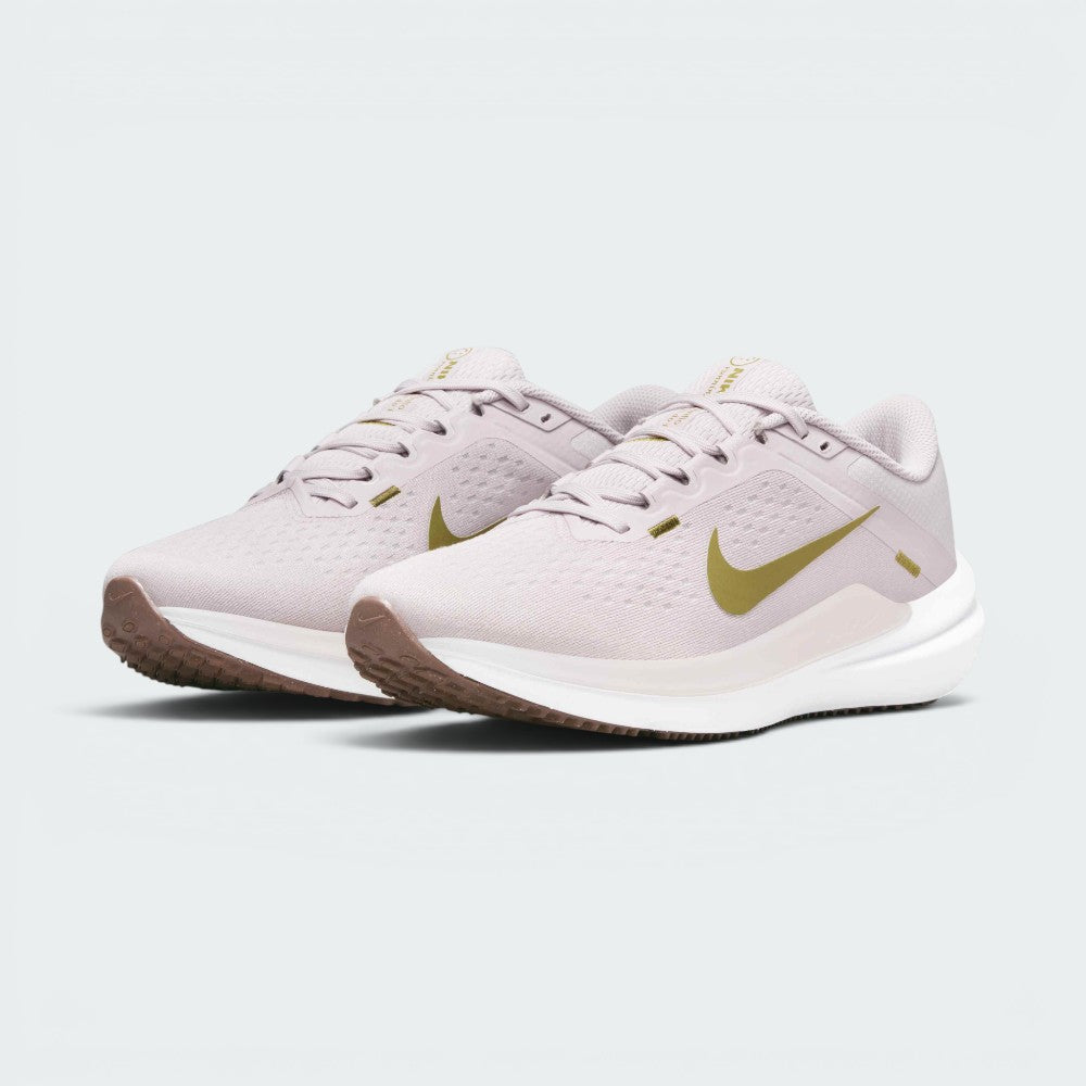 Emphasising the low-cut, athletic running stance of the trainers and the delicate colour harmony of the Platinum Violet uppers sitting cleanly above the white midsoles and brown outsoles.