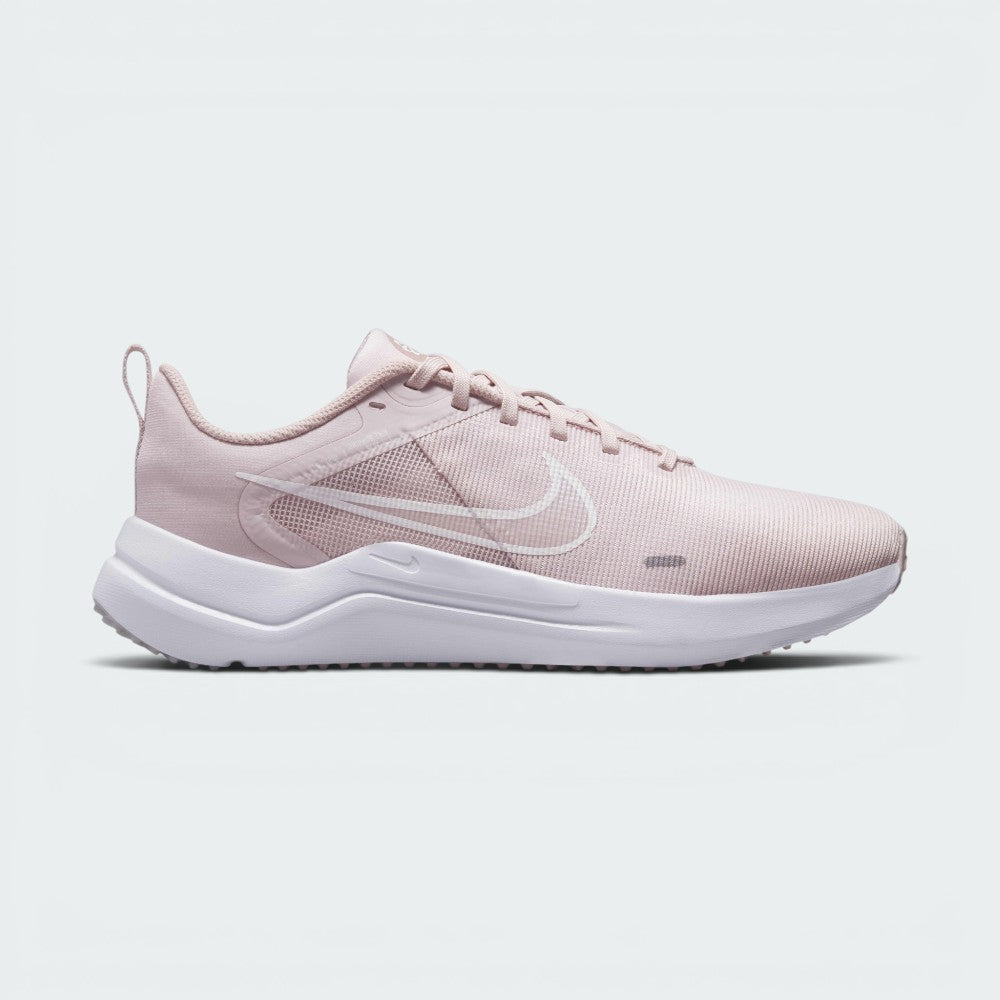 Highlights the lateral profile showing the subtle white printed Swoosh outline over the Barely Rose mesh upper, Pink Oxford midfoot overlay, white foam midsole, and the subtle Sunburst pinwheel logo on the tongue.