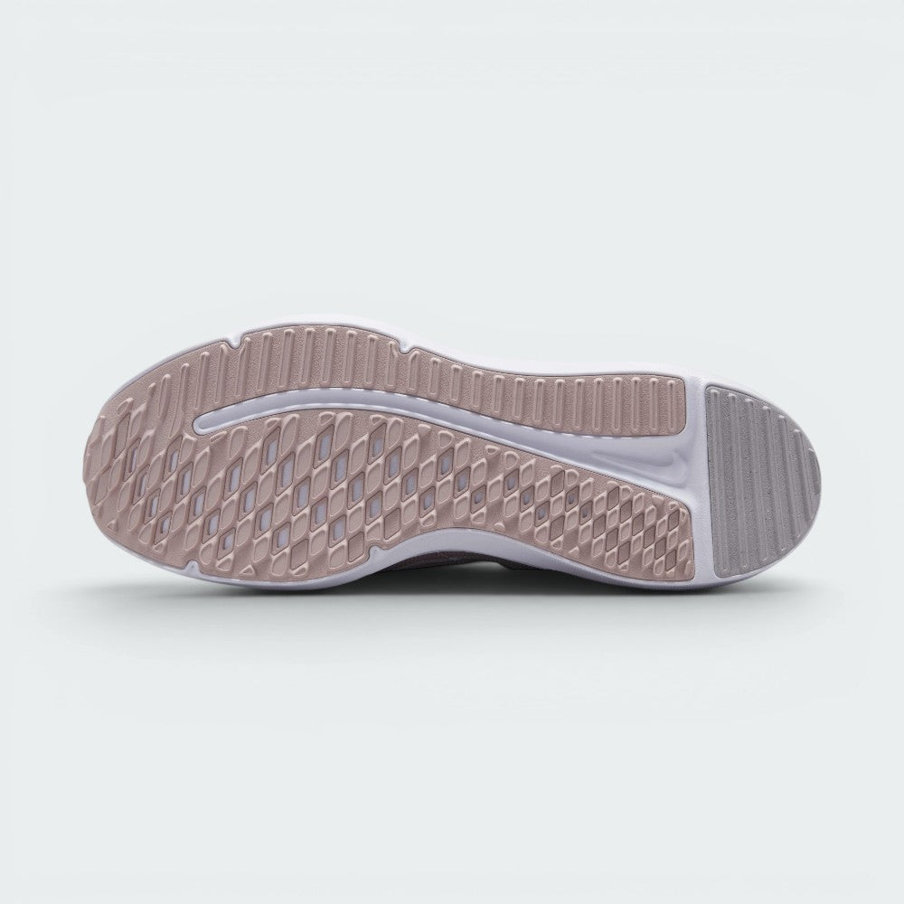 Displays the full-length rubber sole in pink and grey tones, featuring multi-directional flex grooves and a central white cavity exposing the foam cushioning core.