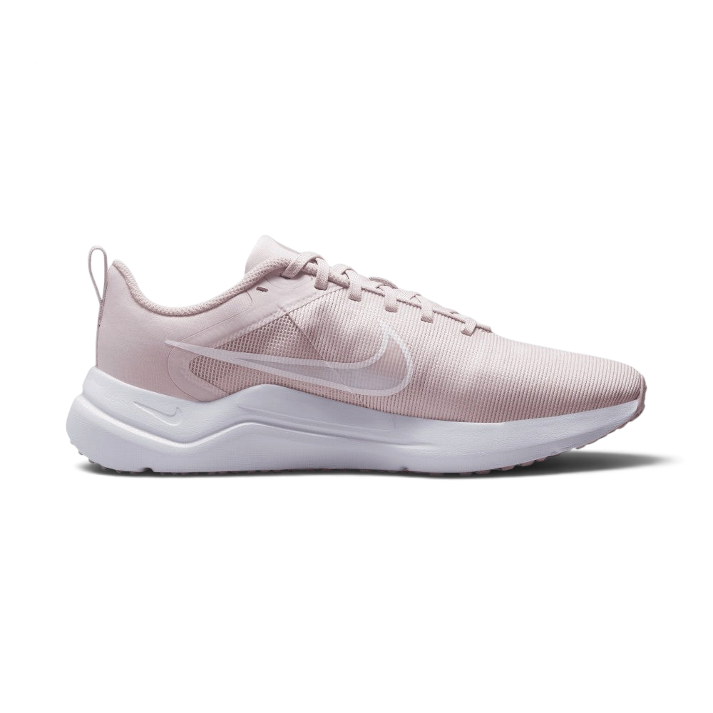 A light pink Nike running shoe with a white sole, shown in a side profile view against a light gray background.