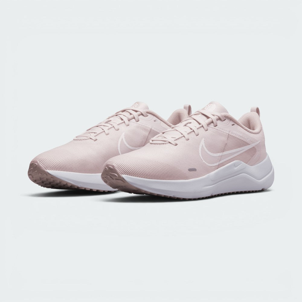 Emphasising the low-cut, forward-leaning running stance of the trainers and the soft colour harmony between the Barely Rose uppers and clean white midsoles.