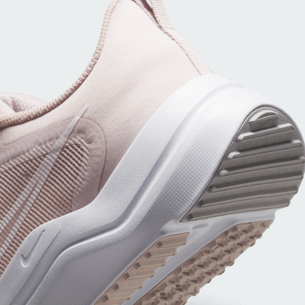 Highlights the "unreal" clean finish where the sculpted white foam midsole meets the Pink Oxford mesh heel counter, displaying the textured rubber tread pods and mini Swoosh accent below.