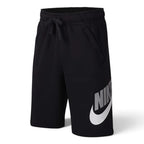 Studio product shot of the Nike Juniors Jersey Shorts in Black laid out on a ghost mannequin, showcasing the elasticated waistband, matching black drawcord, side pockets, and bold white Nike graphic on the left leg.

