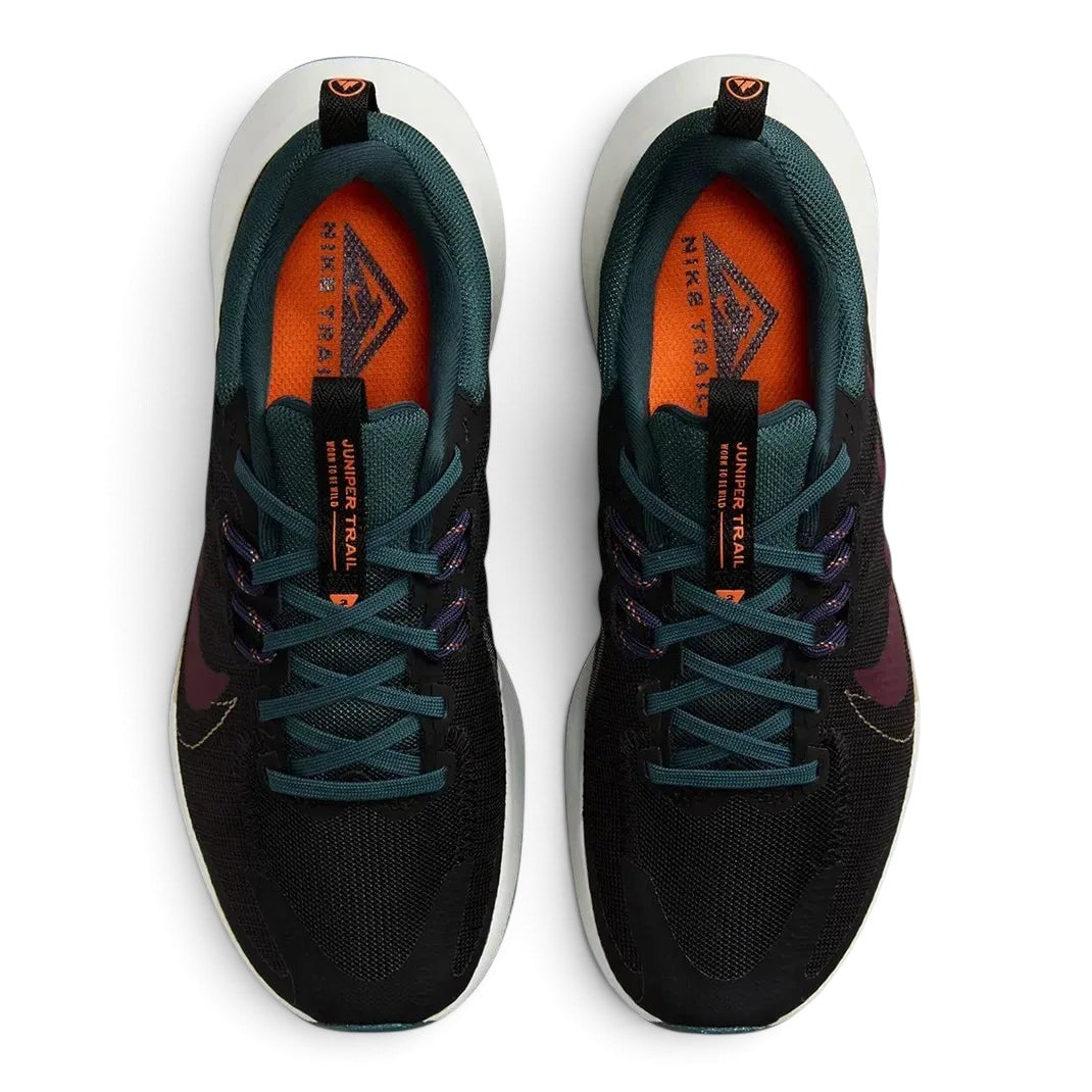 Top-down view of a pair of Nike Juniper Trail 2 Women's trail shoes in black, maroon, and green, highlighting their durable construction and lace-up closure.