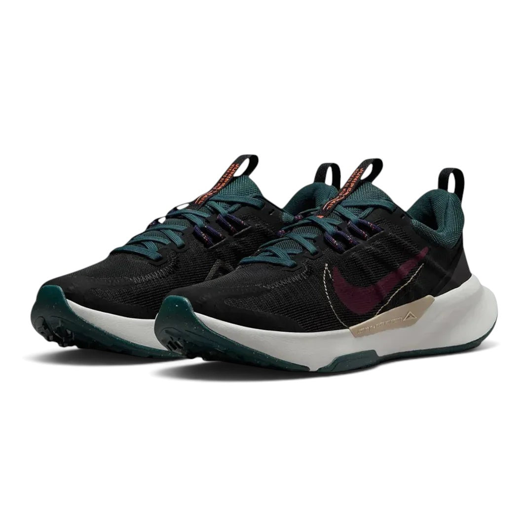 Angled view of two Nike Juniper Trail 2 Women's trail shoes in black and maroon, side by side, showcasing their robust design and athletic silhouette.