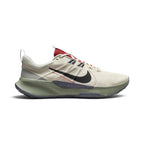 Highlights the rugged lateral profile showing the Light Orewood Brown ripstop mesh upper, textured black Nike Swoosh accented with red contrast stitching, speckled grey sidewall clip stamped with "JUST DO IT • REASON NOT REQUIRED", sage green foam midsole, and dark grey rubber outsole.
