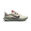 Highlights the rugged lateral profile showing the Light Orewood Brown ripstop mesh upper, textured black Nike Swoosh accented with red contrast stitching, speckled grey sidewall clip stamped with "JUST DO IT • REASON NOT REQUIRED", sage green foam midsole, and dark grey rubber outsole.