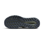 Displays the full-length dark grey rubber sole, showcasing the aggressive tapered lug perimeter, deep central decoupling cavity, and triangular Nike Trail traction badge.