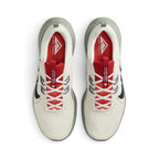 Focuses on the locked-in central lacing layout, displaying the vibrant red mesh tongues with white "JUNIPER TRAIL / WORN TO BE WILD" branded webbing strips, flecked Flywire cable anchors, off-white laces, and bright red insoles stamped with white Nike Trail logos.