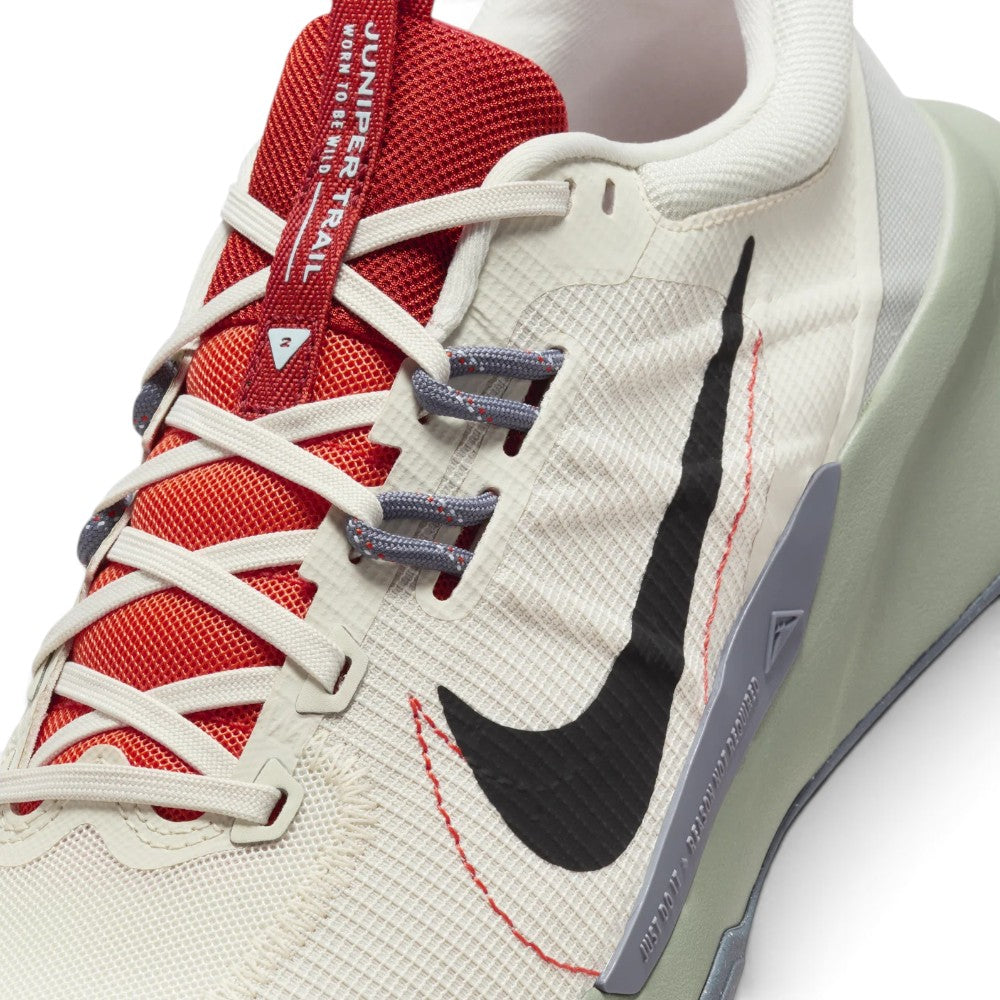 Details the micro-precision of the forefoot, displaying the breathable off-white grid mesh, textured black Swoosh with red perimeter stitching, dual-tone grey Flywire lace loops, and the red branded tongue badge.