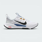 Highlights the lateral profile showing the black Nike Swoosh over white mesh, yellow flywire-style lace loops, deep ocean blue midsole clip with "JUST DO IT" messaging, and the painted red-and-white GR 11 trail marker on the heel foam.