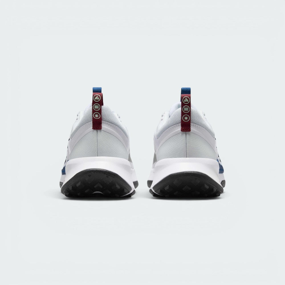Focuses on the rear profile, highlighting the maroon heel pull loops stamped with reflective trail icons and the sturdy white foam heel flare.