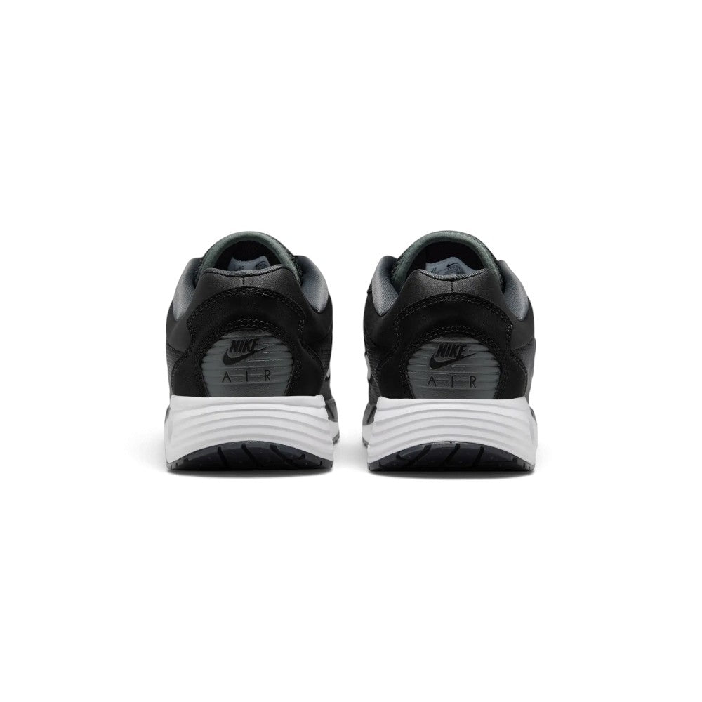 Close-up rear angle focusing on the supportive black heel counter with ribbed texture panels, embroidered Nike Air branding, the curved white midsole stack, and the rear sole footprint.