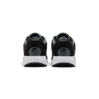 Close-up rear angle focusing on the supportive black heel counter with ribbed texture panels, embroidered Nike Air branding, the curved white midsole stack, and the rear sole footprint.