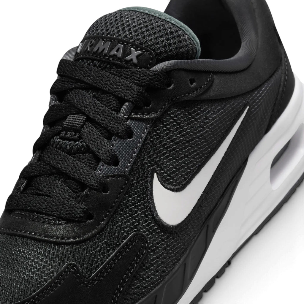 Macro focus on the forefoot and eyestay, detailing the fine mesh texture, synthetic overlay stitching lines, and the padded Air Max tongue label.