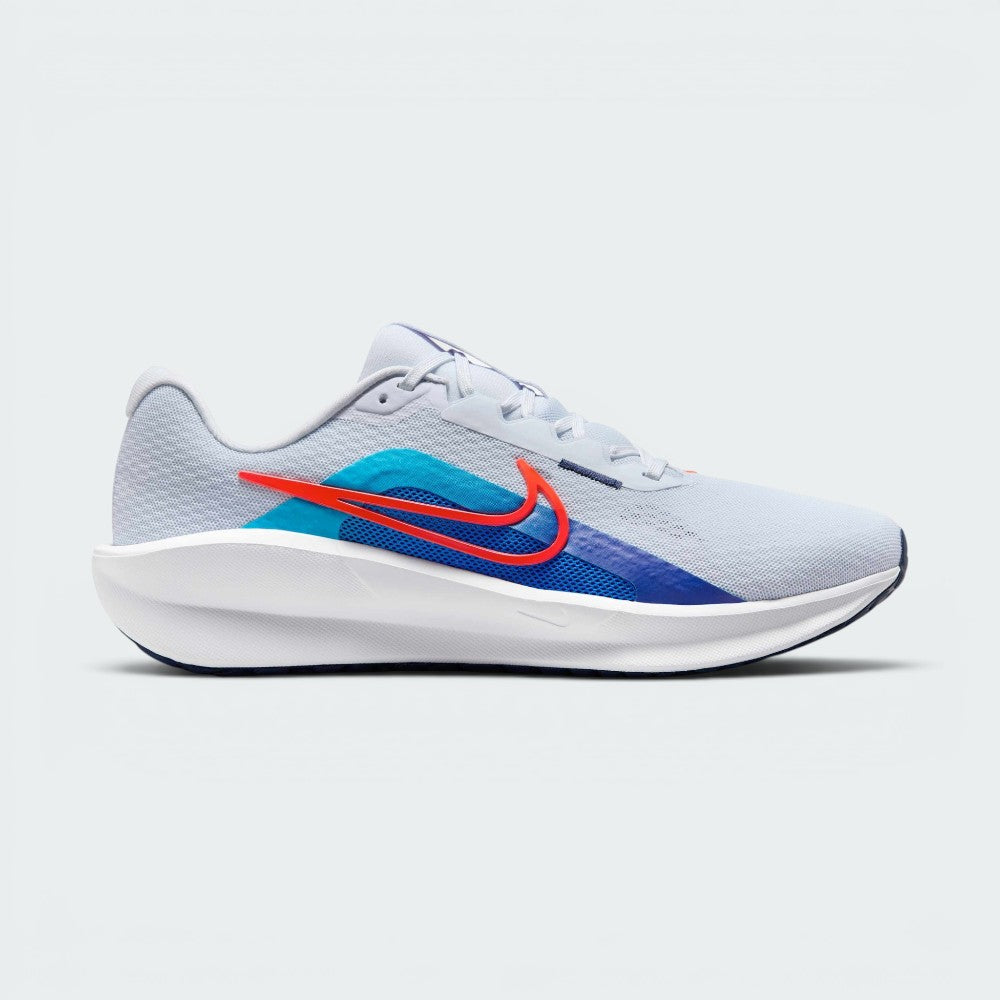 Highlights the high-velocity sweep of the Blue Lightning Nike Swoosh, showing the professional, texturized weave of the Football Grey mesh upper resting above the thick, angular soft white foam midsole wall with pops of Bright Crimson. Main image
