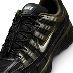 Details the micro-precision of the black mesh toe box, showing the silver metallic Swoosh, reflective eyelet strips, toggle lace lock, and "NIKE" block lettering on the tongue tag.