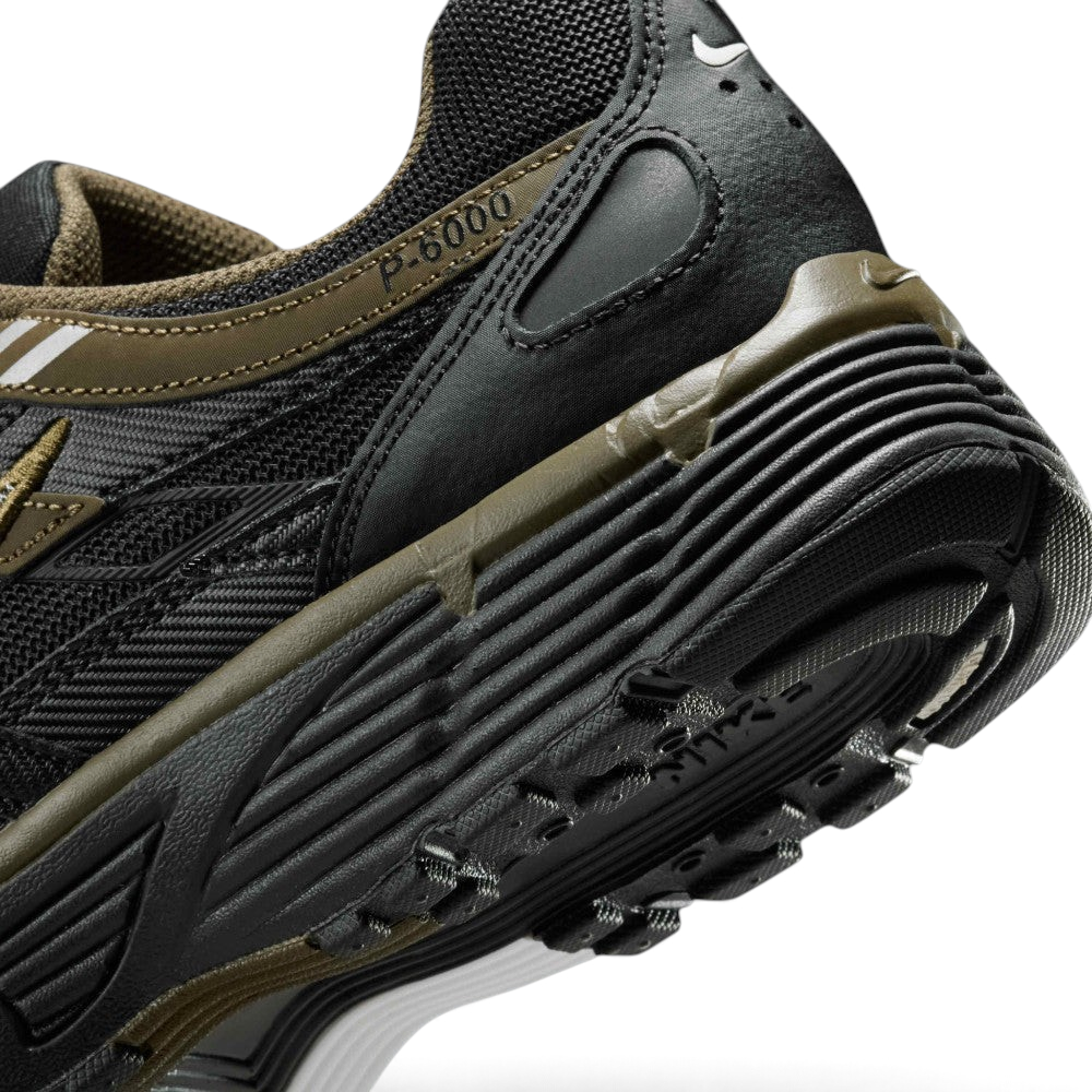 Highlights the "unreal" clean finish where the grooved dark foam midsole meets the black rubber outsole tread, displaying the debossed "P-6000" collar badge and olive heel clip.
