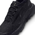 A close-up of a black athletic shoe covered in water droplets, showing its textured knit upper, black laces, and a thick black sole with 'AIRPLATE' branding, on a white background.