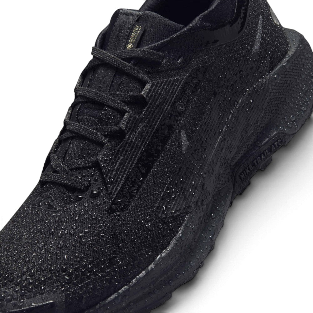 A close-up of a black athletic shoe covered in water droplets, showing its textured knit upper, black laces, and a thick black sole with 'AIRPLATE' branding, on a white background.