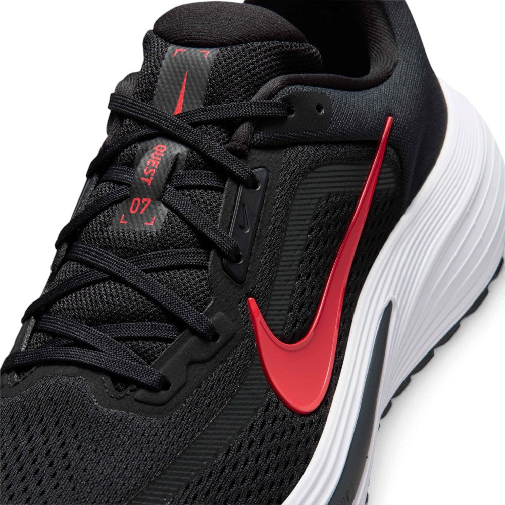 A close-up of a Nike running shoe in black and red with a white midsole, showing the side profile and lace area.