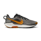 Highlights the rugged lateral silhouette showing the Black and College Grey open-hole mesh upper, Desert Ochre Nike Swoosh, Fir green support accents, thick ReactX foam midsole stamped with trail graphics, and the lugged black rubber ATC outsole.