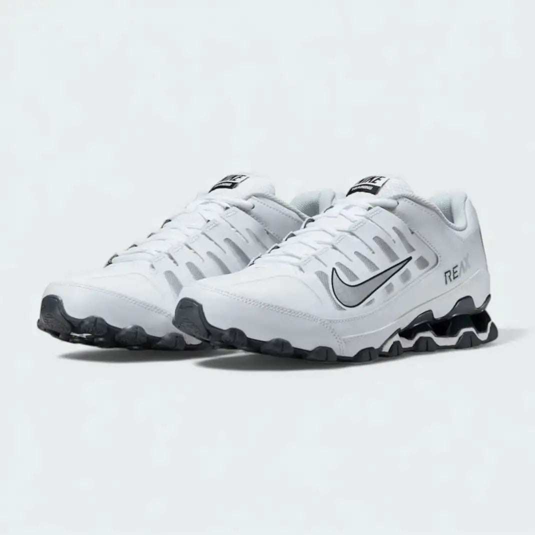 Angled view of two Nike Reax 8 Training Shoes Men's in white and silver, side by side, showcasing their athletic design and mechanical cushioning.