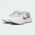 Emphasising the low-cut, athletic running stance of the trainers, highlighting the delicate color harmony of the white, silver, and soft ocean cube blue paneling.