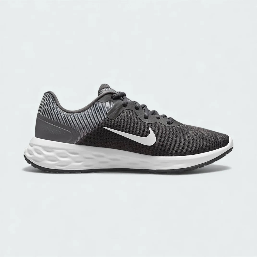 Nike Revolution 6 Next Nature Men's running trainers in iron grey with a white midsole, side profile showing mesh upper, soft foam cushioning, and Nike Swoosh.