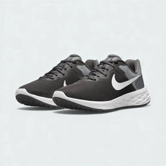 Angled view of two Nike Revolution 6 Next Nature Men's grey and white running trainers, side by side, showcasing their versatile design and cushioned profile.