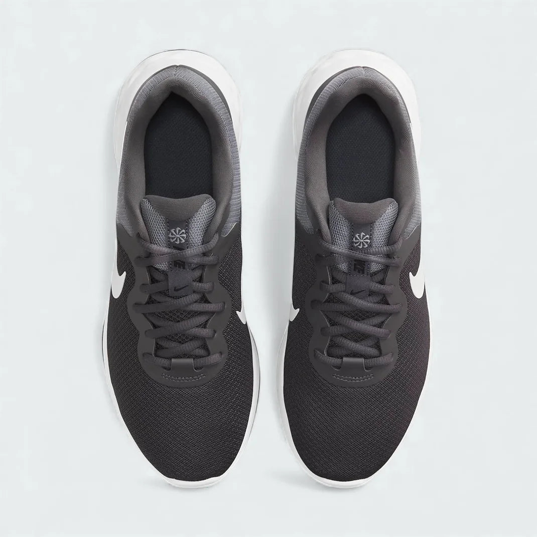 Top-down view of a pair of Nike Revolution 6 Next Nature Men's running trainers in grey, highlighting their streamlined silhouette and lace-up closure.