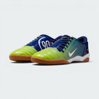 Emphasising the classic, aggressive athletic stance of the trainers and the striking contrast between the deep blue body and vibrant atomic green branding accents.