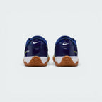 Focuses on the contoured shape of the padded ankle collar, highlighting the structured blue heel counter accented with the bold Atomic Green Total 90 badge.