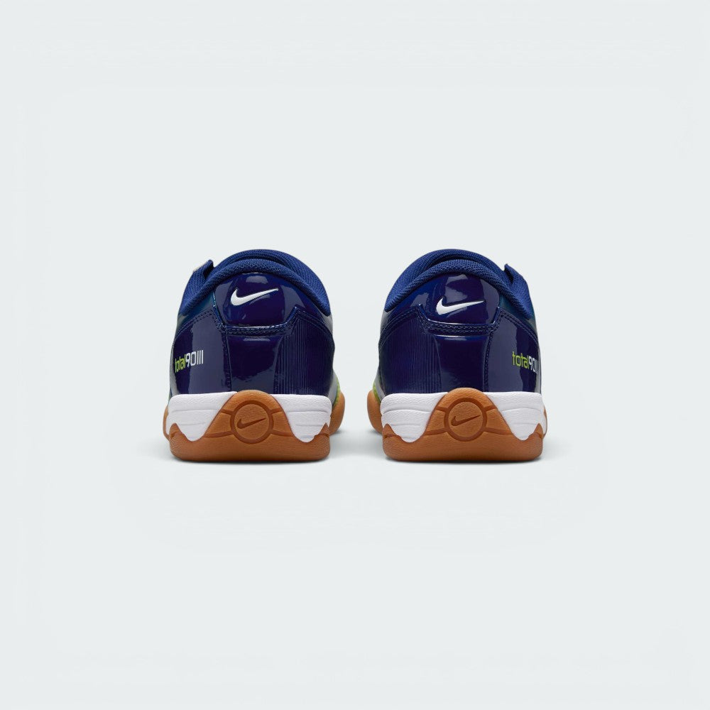 Focuses on the contoured shape of the padded ankle collar, highlighting the structured blue heel counter accented with the bold Atomic Green Total 90 badge.