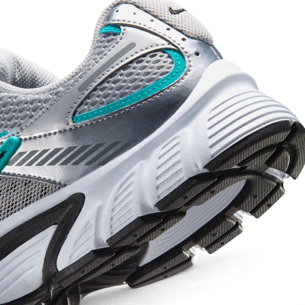 Macro view of the lateral heel transition, highlighting the sculpted white foam midsole, black stability shank, and durable rubber outsole tread.