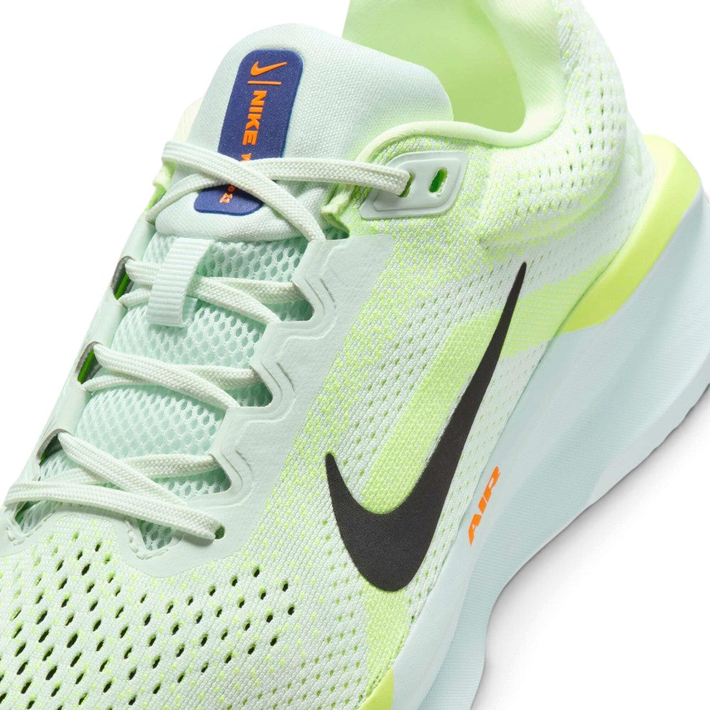 Close-up of a Nike running shoe in light mint green and neon yellow-green, with a black Swoosh logo, orange 'AIR' text, and a blue Nike tab on the tongue.