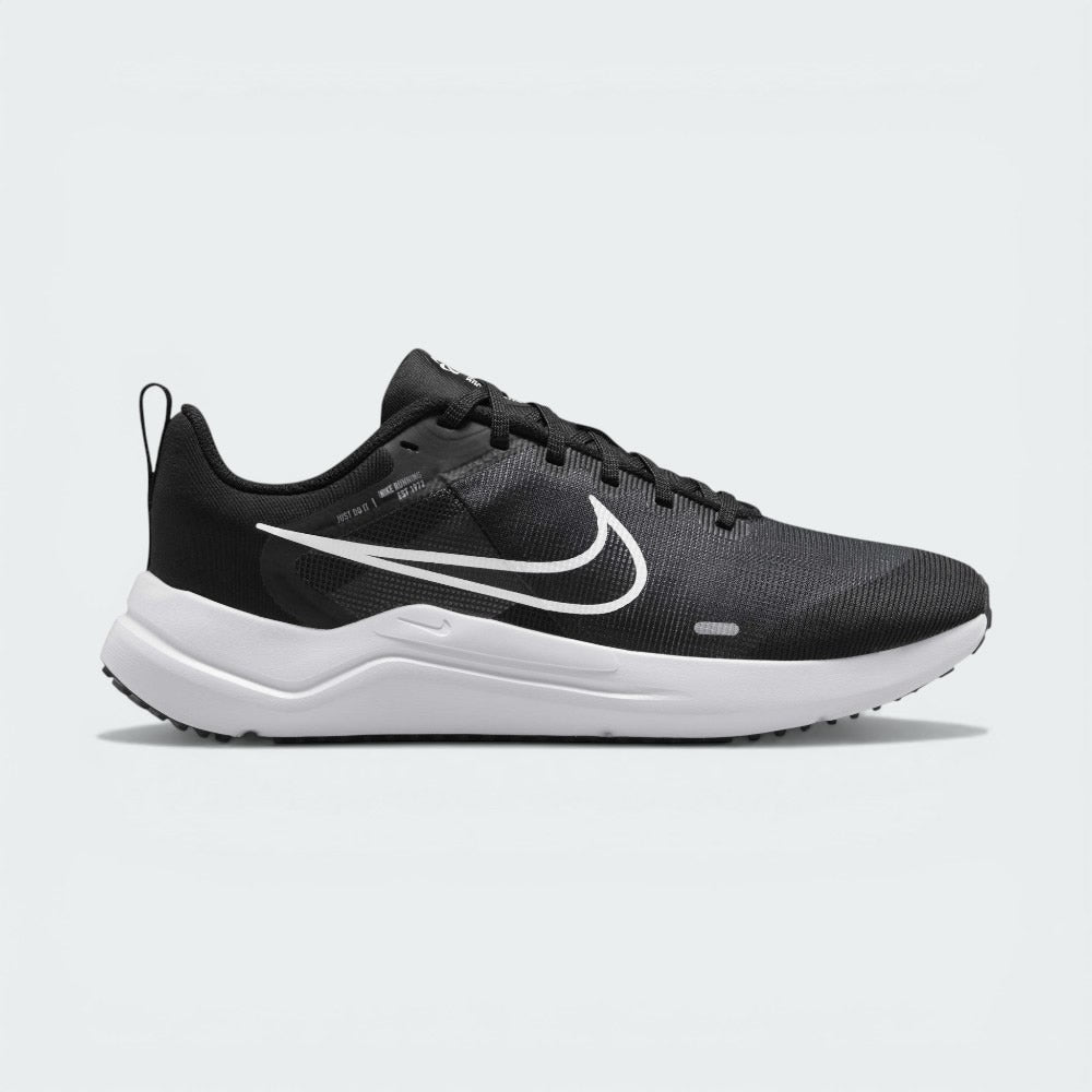 Side Profile Image: The Black Downshifter 12, highlighting the bold White Swoosh and the elevated Smoke Grey foam midsole.