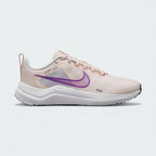 Side Profile Image: The Guava Ice Downshifter 12, highlighting the vibrant Rush Fuchsia Swoosh and the elevated foam midsole.