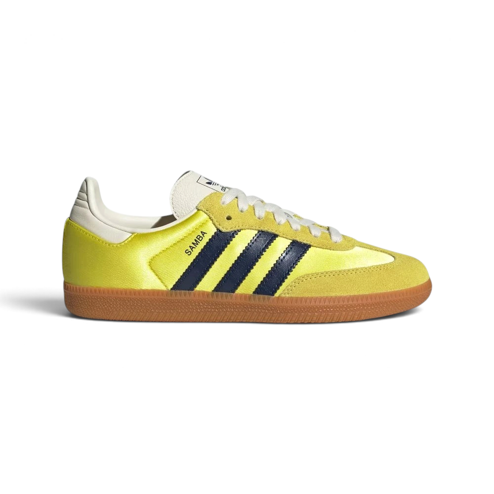 Highlights the high-velocity sweep of the Night Indigo serrated 3-Stripes and the professional, glistening textile depth of the Shock Yellow satin panels leading to the clean cream suede accents. Main image