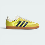 Highlights the high-velocity sweep of the Night Indigo serrated 3-Stripes and the professional, glistening textile depth of the Shock Yellow satin panels leading to the clean cream suede accents.