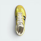 Focuses on the locked-in shoelaces configuration, the clean alignment of the bright yellow satin tongue, and the symmetrical cream white suede toe caps guarding the front box.