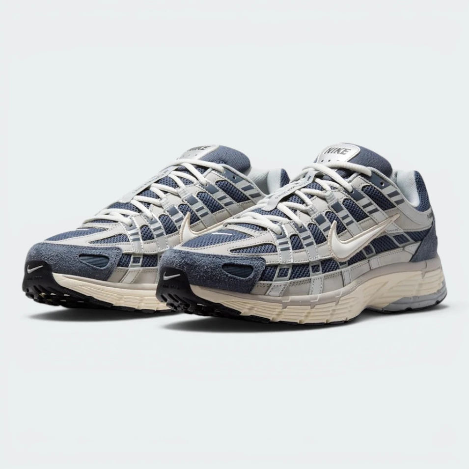 Emphasising the retro-tech, forward-leaning running stance and the professional harmony of the deep navy, slate, and sail contrast panels.