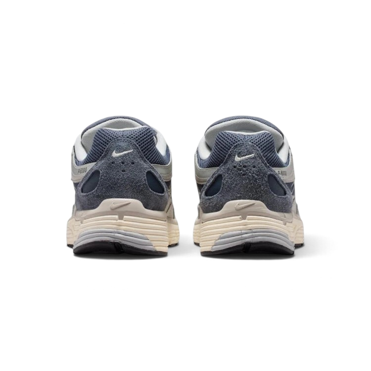 Focuses on the contoured shape of the padded low-cut collar, highlighting the reflective accents and the vertical leather overlay strip tracking down the rear spine.