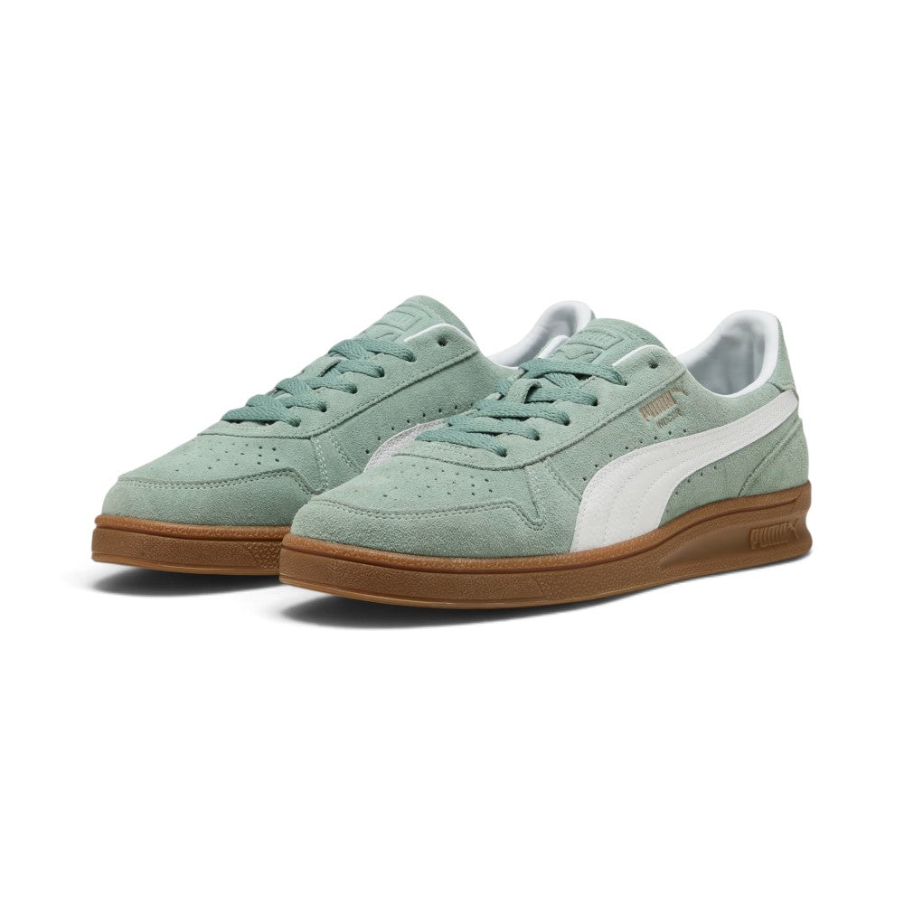 Forward three-quarter angle showcasing both shoes side by side, highlighting the low-slung indoor court stance, perforated suede toe box, tonal green laces, and classic gum cupsole tooling.