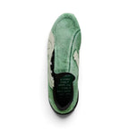 Direct overhead look highlighting the asymmetric rounded toe shape, moss-green hairy suede shroud with exposed lacing throat, and dark interior sockliner printed with handwritten collaborative KidSuper notes.