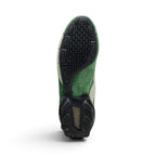 Full-length bottom profile revealing the two-piece segmented black rubber turf outsole, displaying teardrop forefoot studs, deep flex grooves, an exposed hairy suede midfoot arch, and a translucent hexagonal cushioning pod embedded into the decoupled heel.