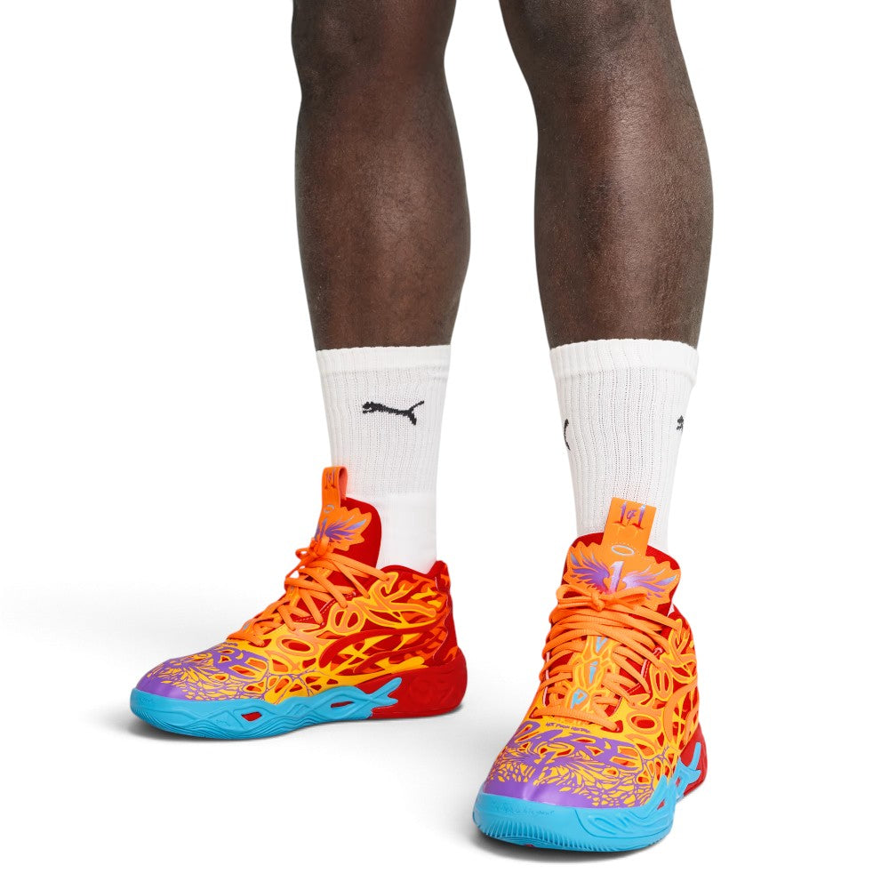 On-court three-quarter perspective showcasing both shoes on-foot with white crew socks, highlighting the high-wrap tongue wings, vibrant multi-tonal flame overlays, and sculpted blue-to-red sole transition