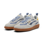 Forward three-quarter angle showcasing both shoes side by side, highlighting the distinctive open-mesh quarter panels, light grey suede T-toe mudguards, lavender-blue laces, dual branded pull loops, and low-profile gum soles.